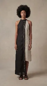 Vestido largo asimétrico, con cuello halter y corte recto. Confeccionado en dos paneles verticales contrastantes: uno negro y otro color cemento/beige claro, unidos por una tira central de encaje negro.
