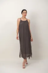 Vestido midi de gasa negro, con solera sin mangas, escote fruncido y detalle de aplique floral en el hombro.
