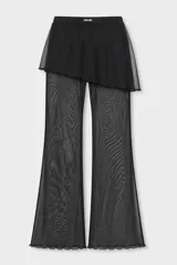 Pantalón de pierna ancha con sobrepollera integrada de tul semitransparente, confeccionado en tela negra liviana. Presenta un diseño de doble capa que aporta movimiento y textura a la prenda.