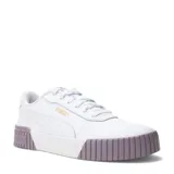 Championes Puma modelo Carina 2.0, de diseño urbano con capellada blanca y suela de plataforma con detalle en color lila. Presenta el logo de la marca en dorado en el lateral y en relieve en la parte trasera de la suela.