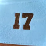 Buzo marrón y celeste de felpa con cuello redondo y mangas largas. Estampado con letras blancas en el pecho.