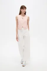 Musculosa cropped de viscosa color rosado, con cuello a la base, pequeña abertura frontal y detalle de hebilla metálica decorativa.