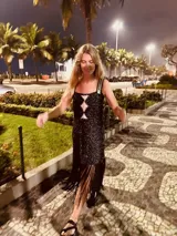 Vestido tejido en lurex color plateado, con diseño geométrico en cuero en el frente y flecos en el ruedo. Breteles finos de cuero con tientos plateados.