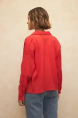 Camisa blanca de manga larga confeccionada en tela texturizada con botones de nácar.