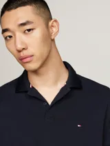 Chomba Tommy Hilfiger color azul marino de piqué de algodón elástico, con cuello clásico, tapeta de dos botones y logo bordado en el pecho.