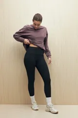 Calza deportiva de tiro alto con pretina ancha, diseñada para brindar sujeción y libertad de movimiento.