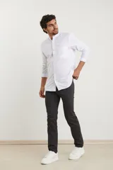 Camisa blanca de manga larga con cuello mao y bolsillo en el pecho.