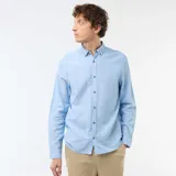 Camisa de manga larga en color azul cielo, confeccionada en mezcla de lino con botones frontales imitación madera y cuello con botones.
