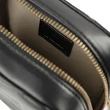 Bandolera negra de cuero sintético con diseño acolchado en forma de chevron. Tiene correa regulable con herrajes dorados, cierre superior y un bolsillo interno con cierre.