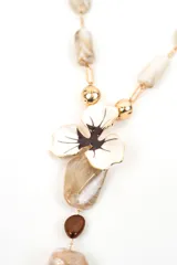 Collar largo con cuentas de piedras en tonos marrones y negros, eslabones dorados y dije central en forma de flor esmaltada con caireles colgantes.
