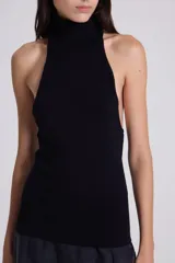 Top negro de punto con cuello alto y sisas amplias.