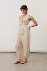 Pantalón holgado negro tipo bombacho, con cintura elástica y puños fruncidos en los tobillos.
