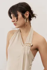 Vestido largo negro de corte al cuerpo con cuello halter y detalle de hebilla metálica dorada en el hombro con tira drapeada.
