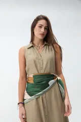 Vestido largo sin mangas de color celeste, con cuello camisero, cierre frontal con botones y bolsillos laterales.