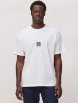 Camiseta blanca de corte oversize, confeccionada en algodón orgánico de alto gramaje. Presenta un diseño gráfico estampado en el centro del pecho con el logo de la marca.