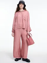 Pantalon de corte amplio y relajado, confeccionado en viscosa con acabado satinado y efecto lavado. Presenta cintura elastizada y detalles de desgaste en costuras y ruedo.