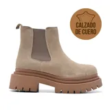 Bota corta de cuero color beige con elásticos laterales y plataforma marrón con suela dentada.