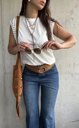 Remera sin mangas de algodón blanco, con cuello redondo y detalle de tachas metálicas en los hombros.
