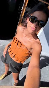 Top strapless de cuero metalizado color dorado, con diseño de tablones verticales en el frente que aportan estructura y elástico en la espalda para un ajuste cómodo.