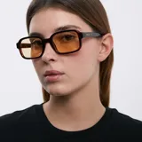 Lentes de sol cuadrados con ángulos redondeados, montura carey y lentes amarillas polarizadas.