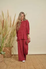 Conjunto de dos piezas color bordó, compuesto por una blusa de manga 3/4 y cuello redondo, y un pantalón de corte recto. Ambas prendas tienen una textura plisada.