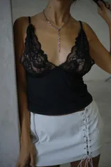 Top negro con escote en V profundo y detalles de encaje floral en el busto, con breteles finos.