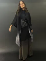 Ruana larga de lana merino color gris con cuello plisado de fieltro. Diseño degradado con terminación en flecos.