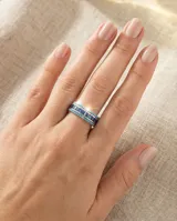 Anillo de plata 925 con diseño de banda, compuesto por una hilera central de circonias cuadradas en color azul zafiro, flanqueadas por dos hileras de pequeñas circonias redondas en color turquesa.