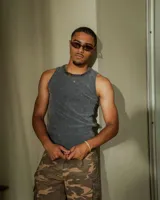 Musculosa de tejido morley lavado, color gris oscuro, con cuello redondo y roturas en el cuello.