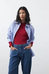 Jean de corte barrel con silueta curva y volumen controlado, de tiro medio y color negro. Presenta un diseño que se ensancha en la pierna y se ajusta levemente en el bajo, con cierre frontal y bolsillos laterales.