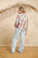 Bomber estampada con diseño abstracto multicolor, cuello mao y cierre frontal con botones dorados.