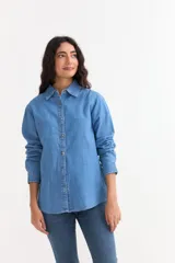 Camisa de jean de manga larga con cuello clásico y cierre frontal de botones. Confeccionada en tejido de algodón, presenta un corte recto y puños abotonados.
