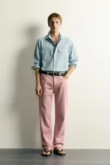 Jeans straight fit de denim de algodón color rosado, con diseño de cinco bolsillos, tiro medio y corte de pierna recta desde la cadera hasta el tobillo. Cuenta con cierre frontal de cremallera y botón metálico.