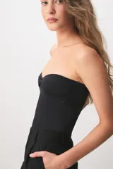Top strapless negro de corte ajustado, con diseño cruzado en el escote delantero.
