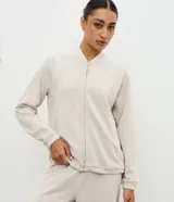 Campera deportiva de cuello alto con cierre frontal, mangas largas con puños elásticos y diseño de corte raglán. Presenta un estilo minimalista y funcional con cintura ajustable.