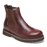 Bota tipo Chelsea de cuero color chocolate, con paneles laterales elásticos, tirador trasero y suela de goma dentada con detalle de corcho en el borde.