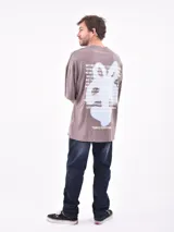 Remera oversize color rosa viejo de manga corta con pequeño estampado blanco en el pecho.