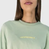 Remera de corte oversize color verde, con estampa tipográfica en color amarillo en la parte superior de la espalda.