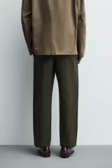 Pantalón de corte relajado confeccionado en una mezcla de algodón y lino. Presenta cintura elástica con cordón ajustable, bolsillos laterales y bolsillos traseros de vivo.