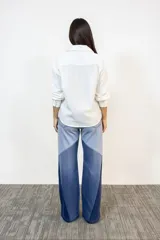 Pantalón de jean con diseño de paneles en tres tonos de azul, corte ancho y tiro alto con cierre de botones a la vista.