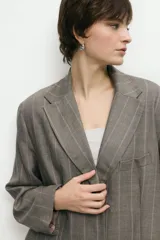 Blazer sastrero negro de corte oversize con solapas de muesca y cierre frontal con dos botones.