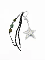 Llavero con mosquetón en forma de corazón, dije de estrella de mar acolchada plateada con tachas doradas, cordón negro y tiras con cuentas de piedra verde.