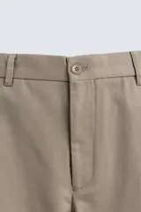 Pantalón de corte recto confeccionado en tejido de algodón con estructura twill, con bolsillos frontales y bolsillos traseros de vivo con botón.