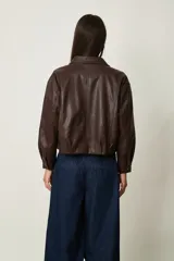 Campera corta de cuero sintético marrón, con cuello camisero y cierre frontal.