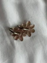 Aros de argolla metálica con dije colgante en forma de flor de acrílico color rosado.