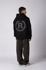Buzo canguro negro con capucha, confeccionado en algodón frizado de alto gramaje. Presenta estampado gráfico en el pecho con tipografía cursiva y texto, además de un logo circular en la manga. Cuenta con bolsillo frontal tipo canguro, puños y ruedo acanalados.