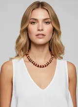 Collar corto de diseño moderno con cuentas en forma de disco en colores bordó y beige. Presenta un acabado brillante y cierre de gancho regulable.