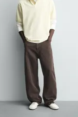 Pantalón de corte baggy fit confeccionado en tejido de algodón con textura y efecto lavado. Presenta diseño de cinco bolsillos, cierre frontal con cremallera y botón.