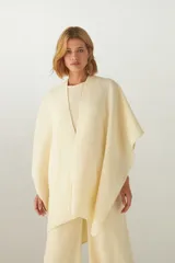 Ruana de lana fina sin teñir, con textura acanalada y terminaciones tejidas a crochet hechas a mano.