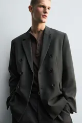 Blazer de corte relajado confeccionada en lana de origen italiano, con diseño de doble botonadura cruzada. Presenta cuello con solapas de muesca, manga larga con botones en puños, bolsillos con solapa en la cadera y abertura central en la espalda. Incluye forro interior a contraste.